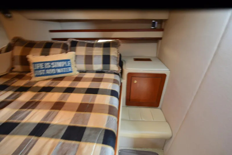 Stage III Yacht Photos Pics Cozy bedroom in 2001 Cruisers Yachts 3750 Motoryacht with plaid bedding and decorative pillow.
