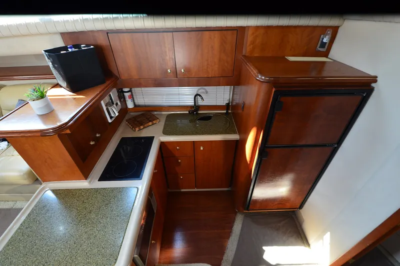Stage III Yacht Photos Pics 2001 Cruisers Yachts 3750 Motoryacht kitchen with wood cabinetry and modern appliances.
