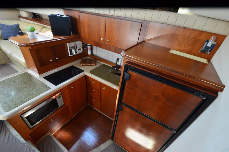 Stage III Yacht Photos Pics Luxurious 2001 Cruisers Yachts 3750 Motoryacht kitchen with wood cabinetry and modern appliances.