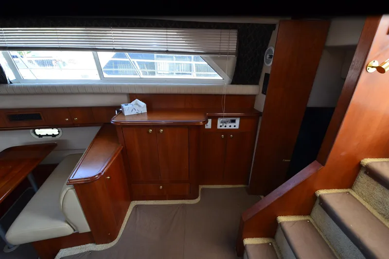 Stage III Yacht Photos Pics 2001 Cruisers Yachts 3750 Motoryacht interior with wooden cabinetry and seating area.
