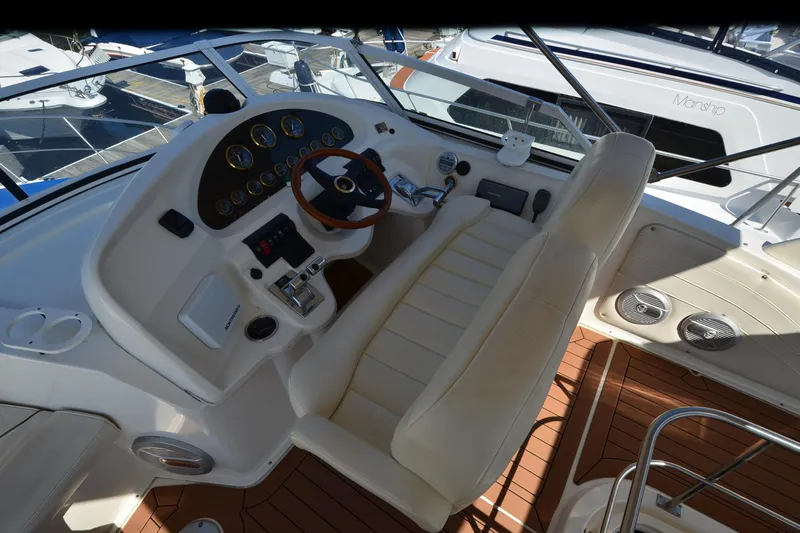 Stage III Yacht Photos Pics 2001 Cruisers Yachts 3750 Motoryacht helm with leather seating and wooden steering wheel.