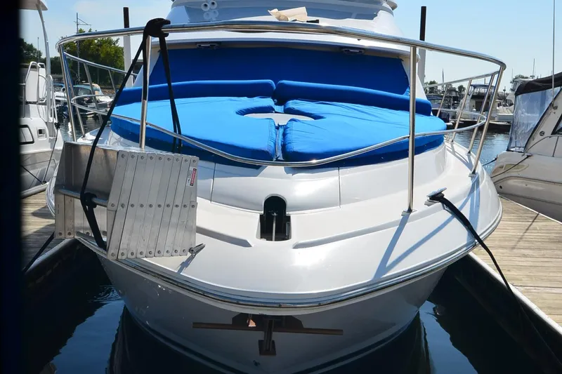 Stage III Yacht Photos Pics 2001 Cruisers Yachts 3750 Motoryacht docked, featuring blue sunbed and stainless steel railings.