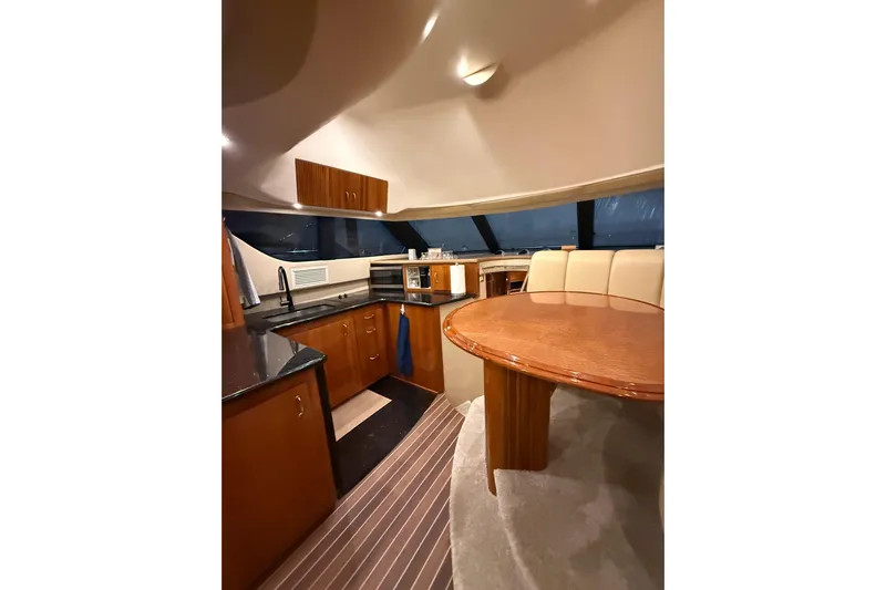 Orion Yacht Photos Pics Luxurious interior of 2004 Carver 460 Voyager yacht with modern kitchen and dining area.