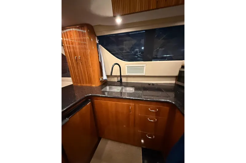 Orion Yacht Photos Pics 2004 Carver 460 Voyager yacht kitchen with wood cabinetry and modern fixtures.