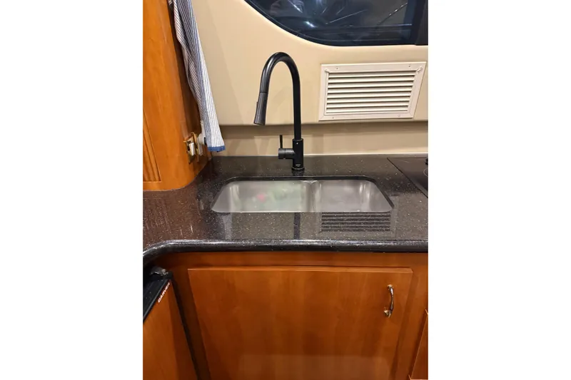 Orion Yacht Photos Pics 2004 Carver 460 Voyager kitchen sink with sleek black faucet and wooden cabinetry.
