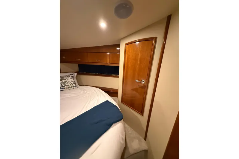 Orion Yacht Photos Pics Interior cabin of 2004 Carver 460 Voyager yacht with wooden door and cozy bed.