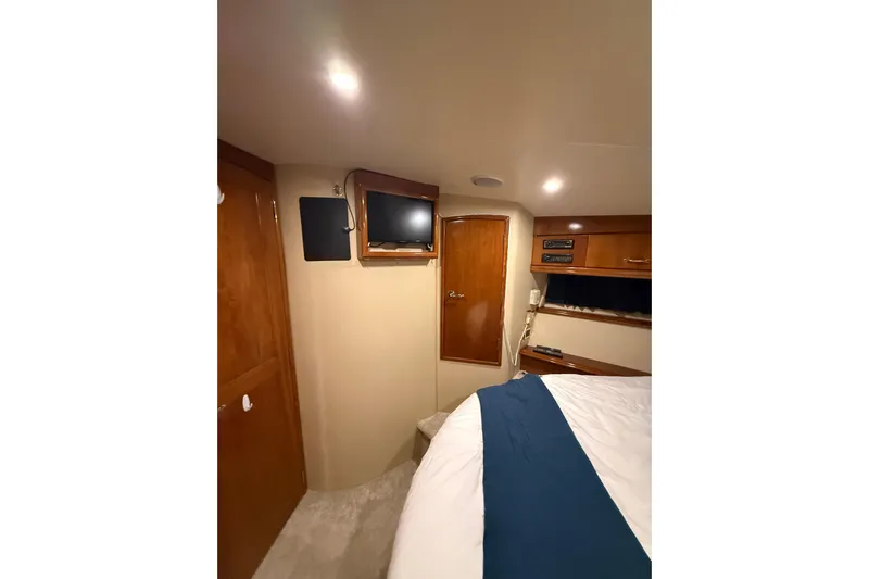 Orion Yacht Photos Pics Interior of 2004 Carver 460 Voyager yacht cabin with TV and wooden cabinetry.