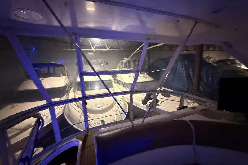 Orion Yacht Photos Pics 2004 Carver 460 Voyager yacht in dimly lit indoor storage, surrounded by other boats.