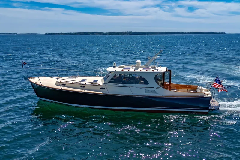 Maine Squeeze Yacht Photos Pics 2009 Hinckley Talaria 44 MY yacht cruising on open water under a clear blue sky.