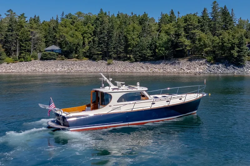 Maine Squeeze Yacht Photos Pics 2009 Hinckley Talaria 44 MY yacht cruising on a scenic lake with forested shoreline.