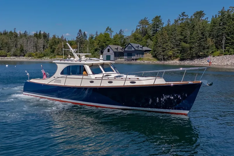 Maine Squeeze Yacht Photos Pics 2009 Hinckley Talaria 44 MY yacht cruising near a forested shoreline.