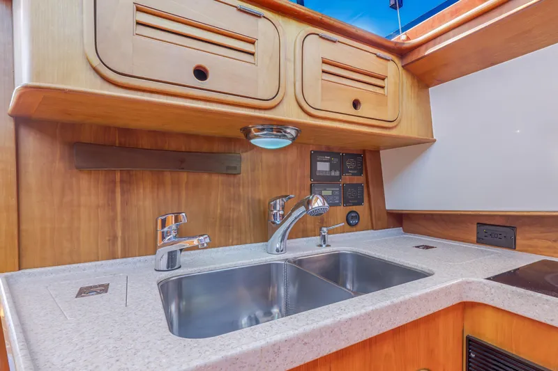 Maine Squeeze Yacht Photos Pics Hinckley Talaria 44 MY 2009 yacht kitchen with wooden cabinets and stainless steel sink.