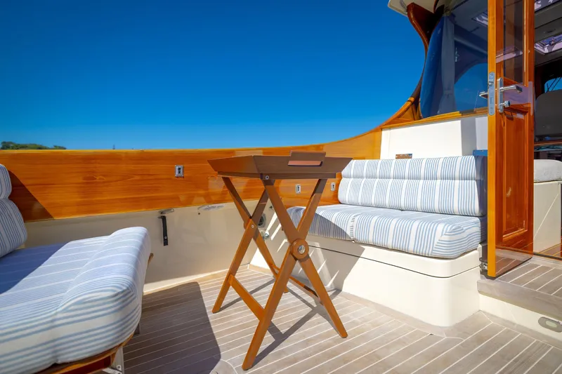 Maine Squeeze Yacht Photos Pics 2009 Hinckley Talaria 44 MY yacht deck with striped seating and wooden table.