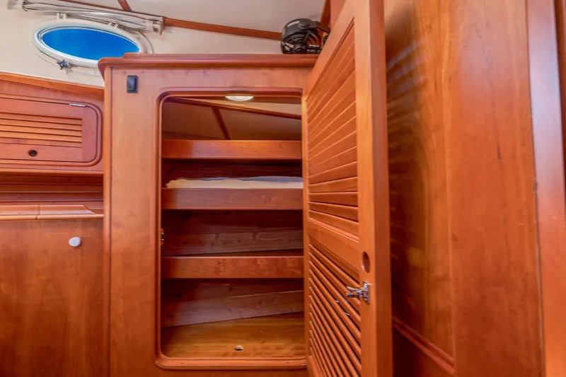 Maine Squeeze Yacht Photos Pics Wooden interior storage on 2009 Hinckley Talaria 44 MY yacht with open shelves and porthole.