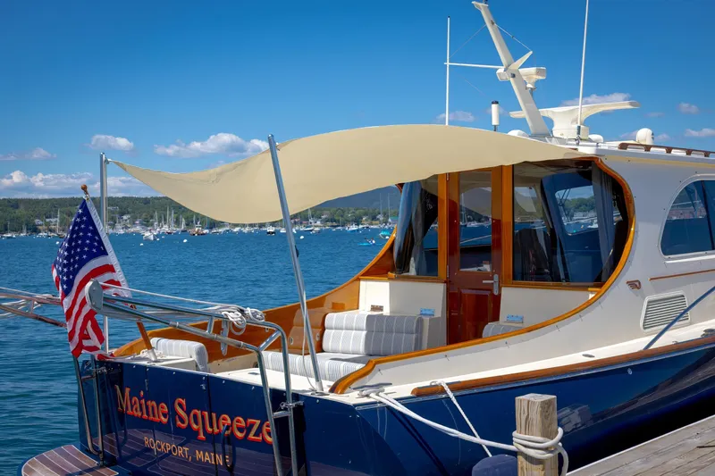 Maine Squeeze Yacht Photos Pics Hinckley Talaria 44 MY 2009 yacht docked in Rockport, Maine, with American flag.