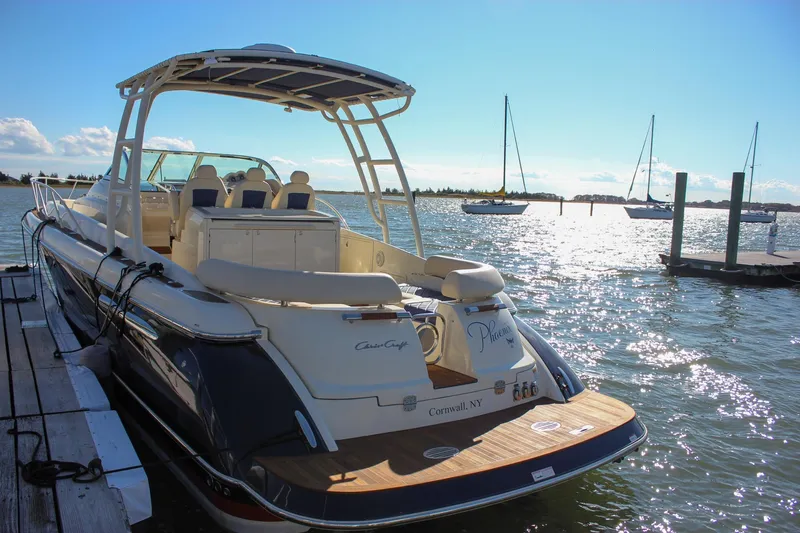 Phoenix Yacht Photos Pics 2017 Chris-Craft Launch 38 docked, sunlit water, and sailboats in the background.