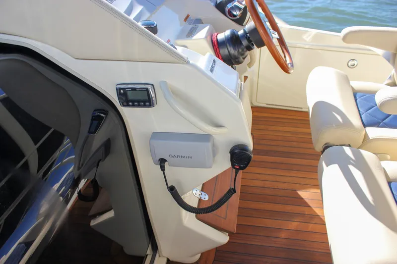 Phoenix Yacht Photos Pics 2017 Chris-Craft Launch 38 helm with Garmin device, wooden steering wheel, and luxurious seating.