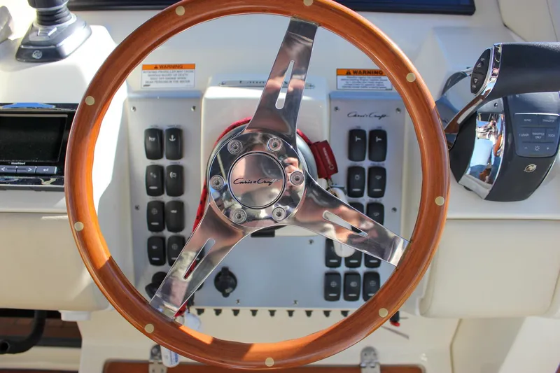 Phoenix Yacht Photos Pics Steering wheel of 2017 Chris-Craft Launch 38 boat, featuring wood and metal design.