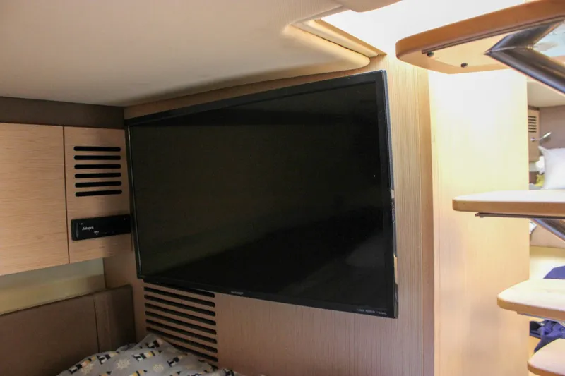 Phoenix Yacht Photos Pics 2017 Chris-Craft Launch 38 interior with mounted flat-screen TV and wooden cabinetry.