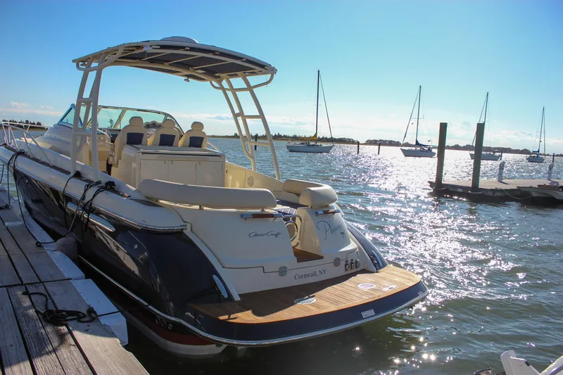Phoenix Yacht Photos Pics 2017 Chris-Craft Launch 38 docked at a sunny marina with sailboats in the background.