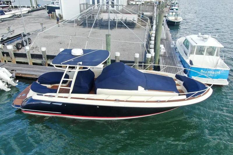 Phoenix Yacht Photos Pics 2017 Chris-Craft Launch 38 boat docked at marina, covered with blue tarps.