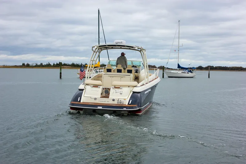 Phoenix Yacht Photos Pics 2017 Chris-Craft Launch 38 boat cruising on calm waters, with sailboats in the background.