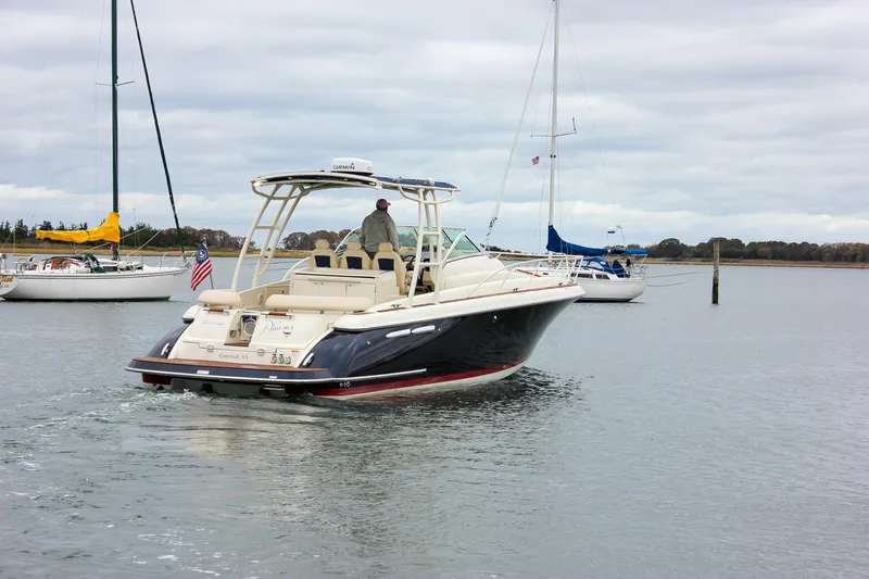 Phoenix Yacht Photos Pics 2017 Chris-Craft Launch 38 boat cruising in a calm harbor with sailboats nearby.