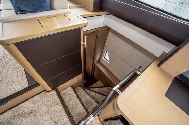 Seeworthy Yacht Photos Pics Interior staircase of 2018 Prestige 560 yacht, featuring modern wood and metal design.