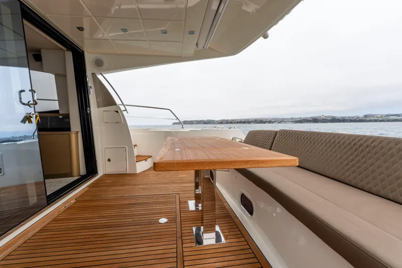 Seeworthy Yacht Photos Pics Luxurious 2018 Prestige 560 yacht deck with elegant seating and wooden table.