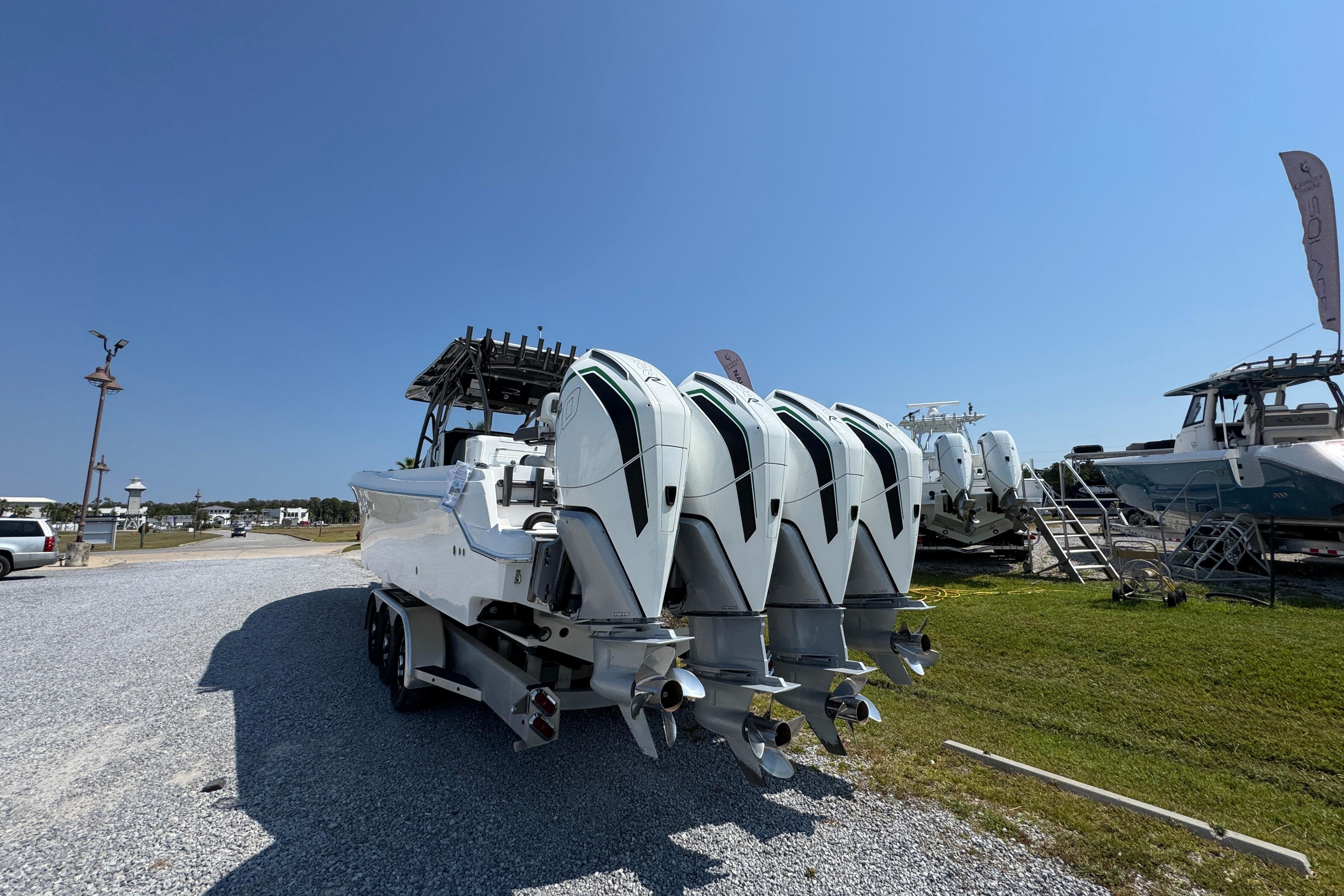 2022 Nor-Tech 392 Super Fish boat with four powerful outboard engines, parked on gravel.