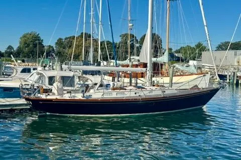 Symphony V Yacht Photos Pics Sailboat Hinckley Sou'wester 52, 1999 model, docked in a marina under clear blue skies.