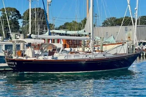 Symphony V Yacht Photos Pics 1999 Hinckley Sou'wester 52 sailboat docked in a marina under clear blue skies.