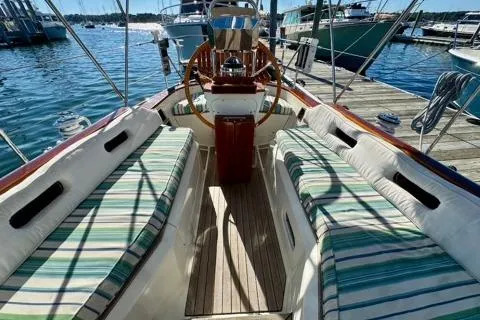 Symphony V Yacht Photos Pics Cockpit of 1999 Hinckley Sou'wester 52 sailboat with striped seating, docked at marina.
