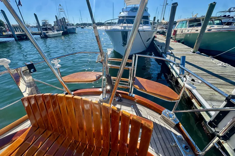Symphony V Yacht Photos Pics Hinckley Sou'wester 52 sailboat, 1999 model, docked at marina with polished wooden seating.