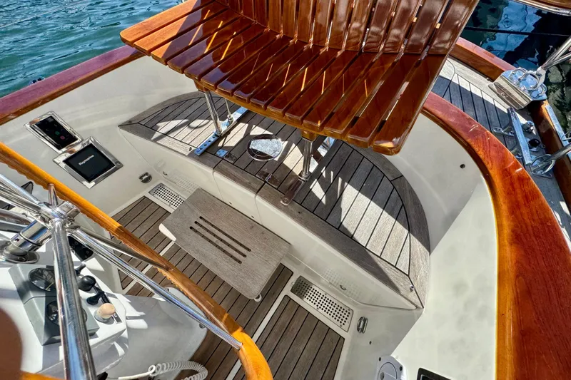 Symphony V Yacht Photos Pics Cockpit of 1999 Hinckley Sou'wester 52 yacht with wooden seating and steering wheel.