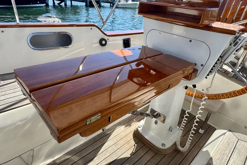 Symphony V Yacht Photos Pics Polished wooden helm station on 1999 Hinckley Sou'wester 52 sailboat, docked by the water.