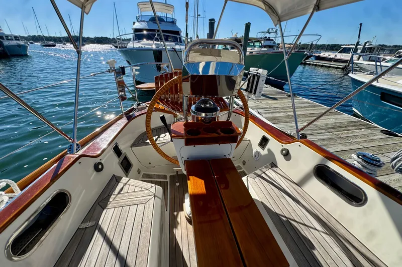 Symphony V Yacht Photos Pics Cockpit of 1999 Hinckley Sou'wester 52 yacht docked at marina, featuring wooden accents.