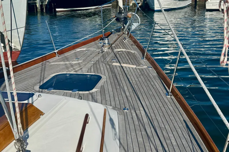 Symphony V Yacht Photos Pics Hinckley Sou'wester 52 sailboat deck, 1999 model, with wooden finish and ocean backdrop.