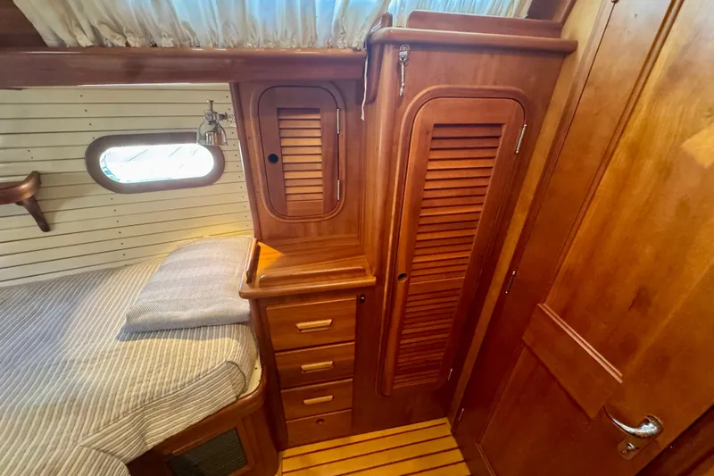 Symphony V Yacht Photos Pics Hinckley Sou'wester 52 (1999) cabin interior with wooden cabinetry and cozy bed.