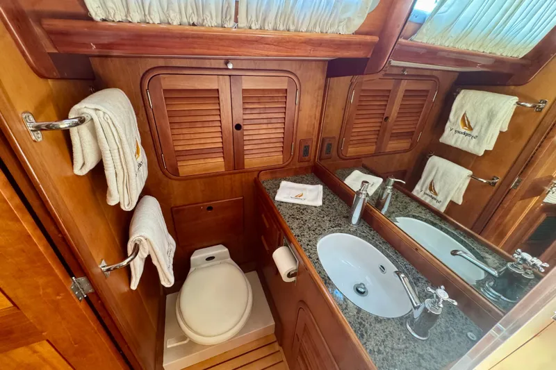 Symphony V Yacht Photos Pics Luxurious 1999 Hinckley Sou'wester 52 yacht bathroom with wood accents and granite countertop.