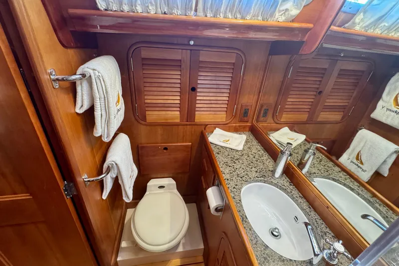 Symphony V Yacht Photos Pics Luxurious 1999 Hinckley Sou'wester 52 yacht bathroom with wood accents and granite countertop.