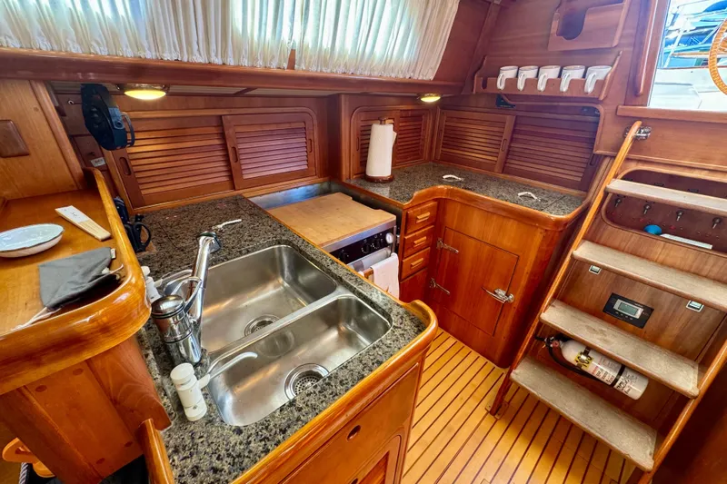 Symphony V Yacht Photos Pics Luxurious 1999 Hinckley Sou'wester 52 yacht kitchen with wooden cabinetry and granite countertops.