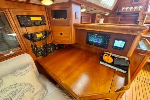 Symphony V Yacht Photos Pics Navigation station of 1999 Hinckley Sou'wester 52 yacht with wooden interior and modern instruments.