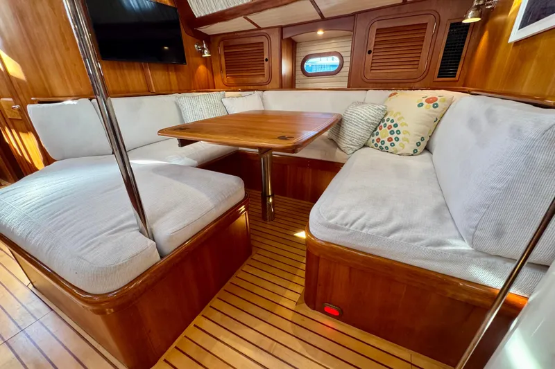 Symphony V Yacht Photos Pics Luxurious interior of 1999 Hinckley Sou'wester 52 yacht with cozy seating and wooden finishes.