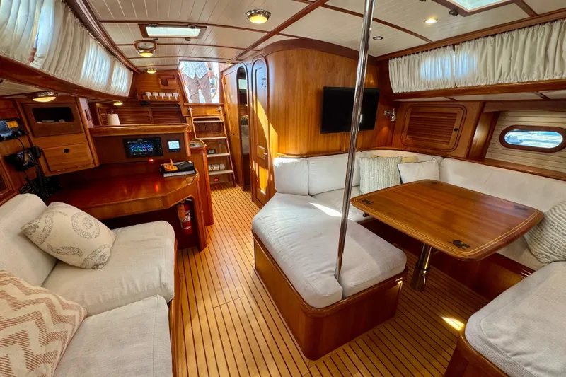 Symphony V Yacht Photos Pics Luxurious interior of 1999 Hinckley Sou'wester 52 yacht with wooden furnishings and cozy seating.