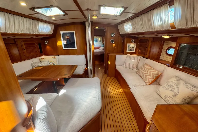 Symphony V Yacht Photos Pics Luxurious interior of 1999 Hinckley Sou'wester 52 yacht with elegant wood finish and cozy seating.