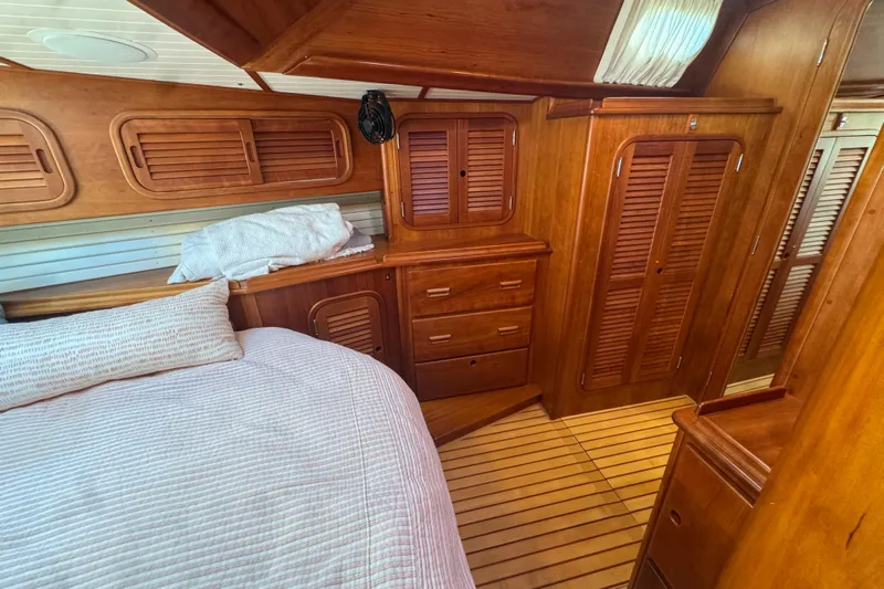 Symphony V Yacht Photos Pics Hinckley Sou'wester 52 yacht interior, 1999 model, featuring wooden cabinetry and cozy bedding.