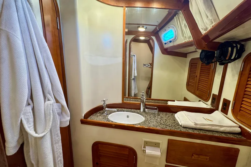 Symphony V Yacht Photos Pics Luxurious bathroom in 1999 Hinckley Sou'wester 52 yacht with granite countertop and wooden accents.