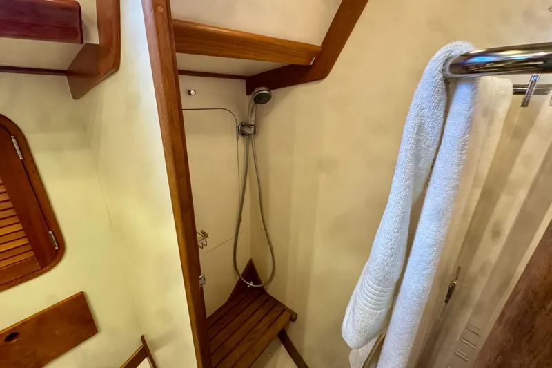 Symphony V Yacht Photos Pics Shower area in 1999 Hinckley Sou'wester 52 yacht with wooden accents and towel rack.