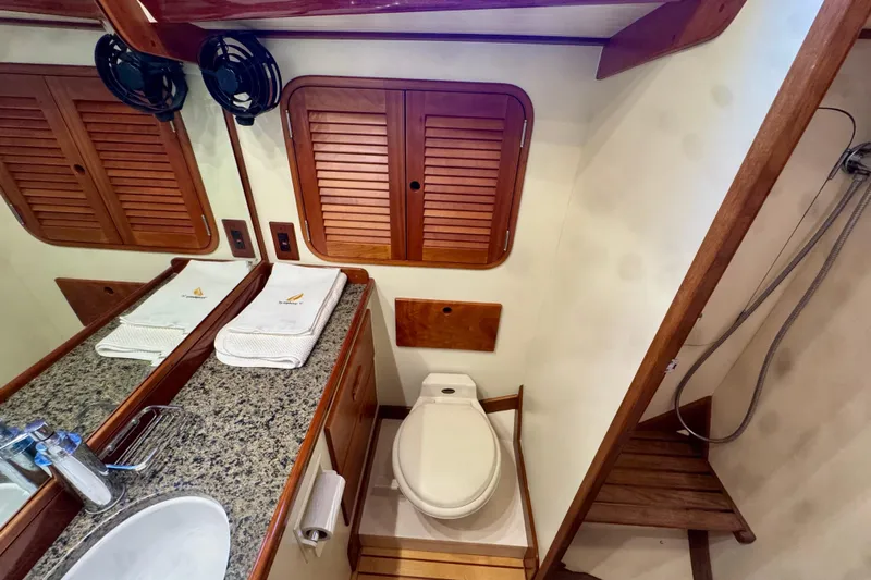 Symphony V Yacht Photos Pics Luxurious bathroom in 1999 Hinckley Sou'wester 52 yacht with granite countertop and wooden accents.